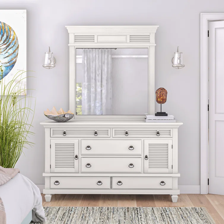 Large white dresser with mirror featuring louvered details and multiple storage compartments in coastal-themed bedroom