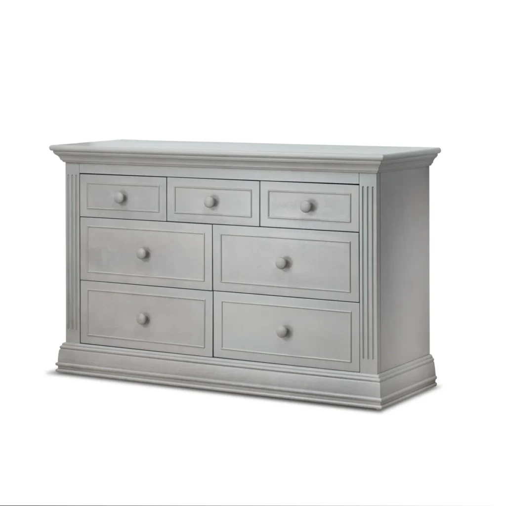 Light gray painted seven-drawer dresser with traditional molding details and round wooden knobs on white background
