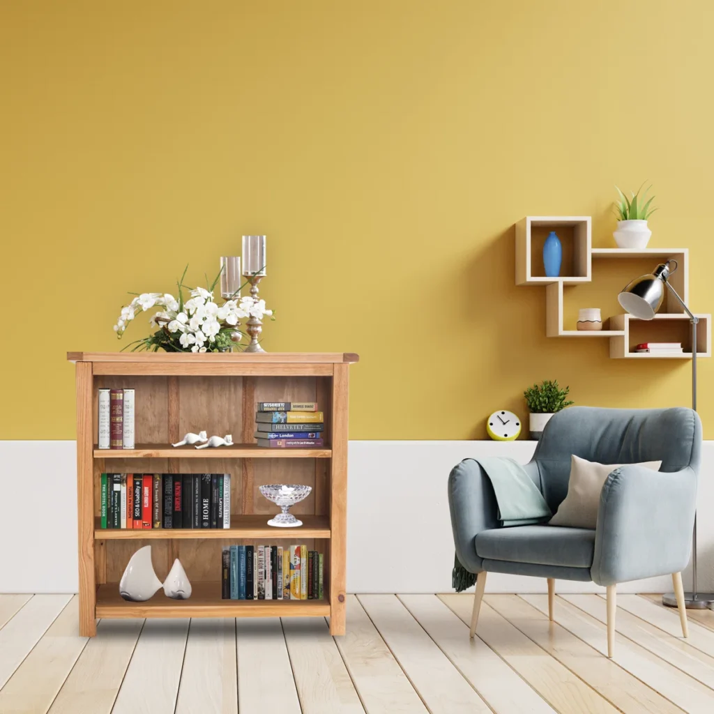 Compact wooden bookcase with three shelves displaying books in bright living room