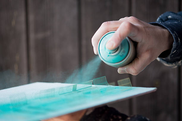 Woodworker sanding solid wood furniture with power tool, preparing surface for painting wood furniture